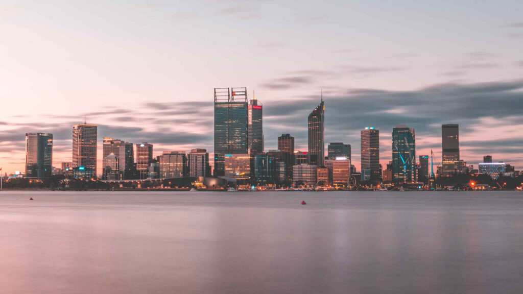 View of the Perth skyline from the water at sunrise, in Australia.