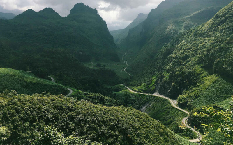View of a valley with a winding road in Ha Giang province, Vietnam.